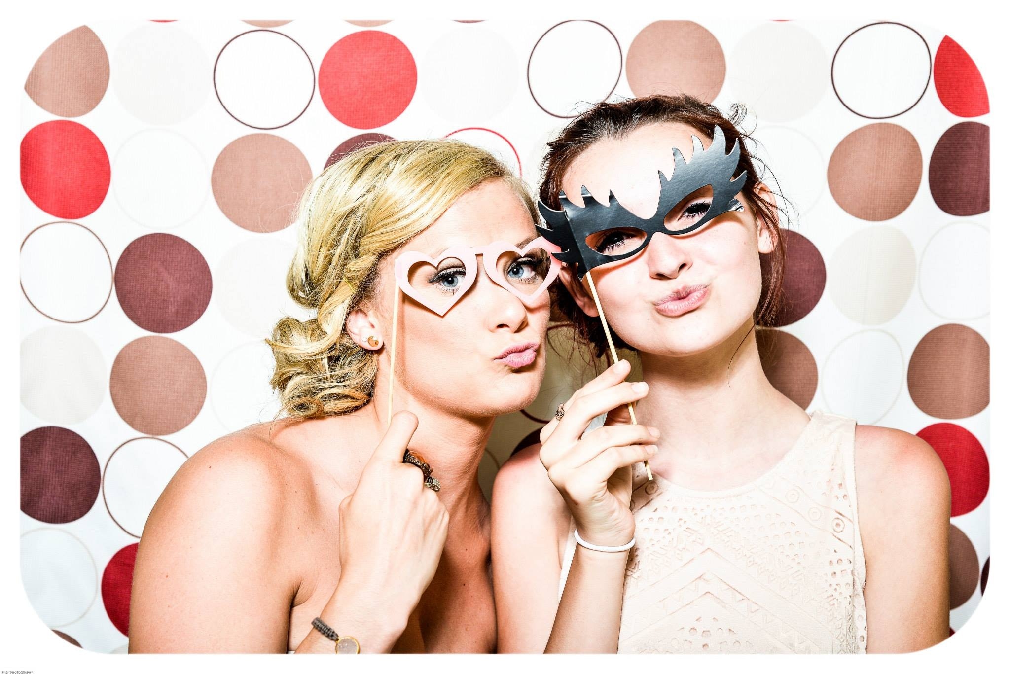 Two women taking picture in photo booth. See our photo booth options.